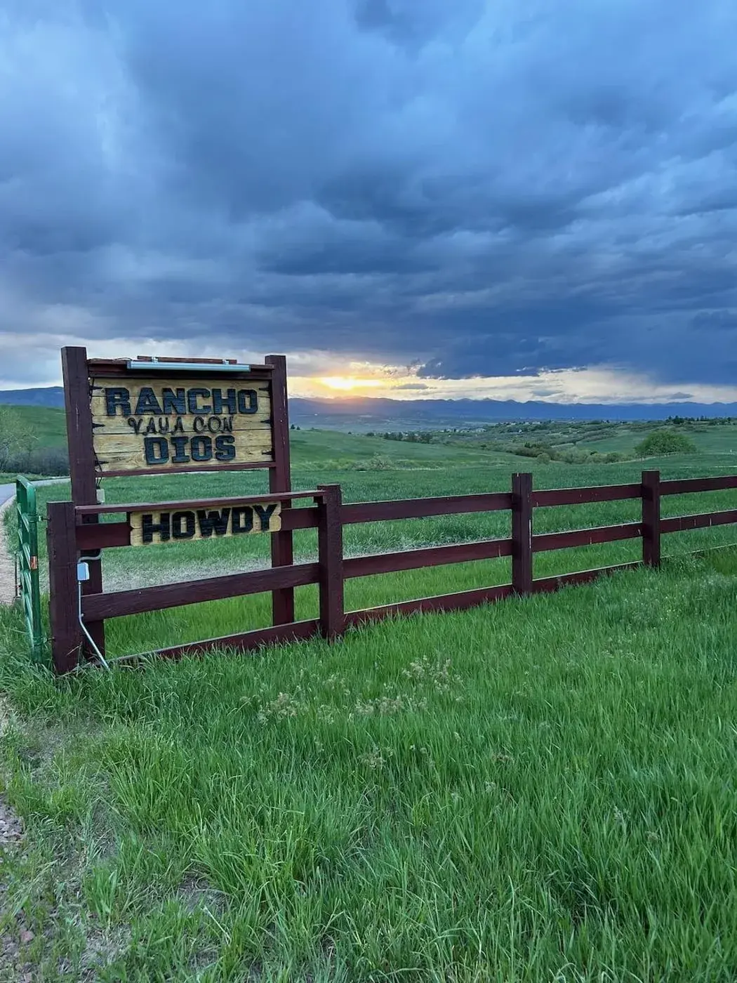 The Rancho Vaya Con Dios ranch entrance sign at sunset